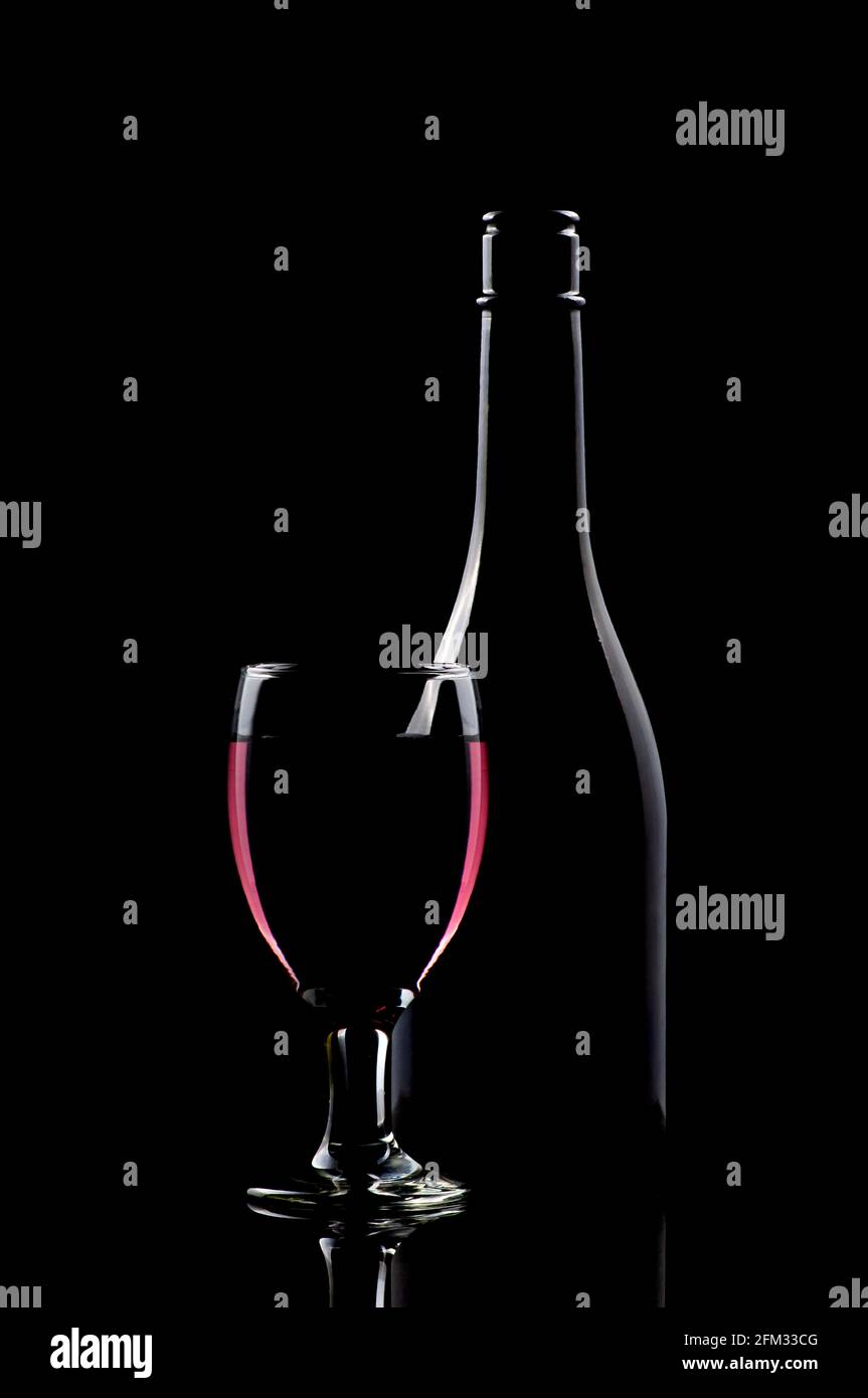 Ein Glas Rotwein neben einer Flasche auf einem Tabelle Stockfoto