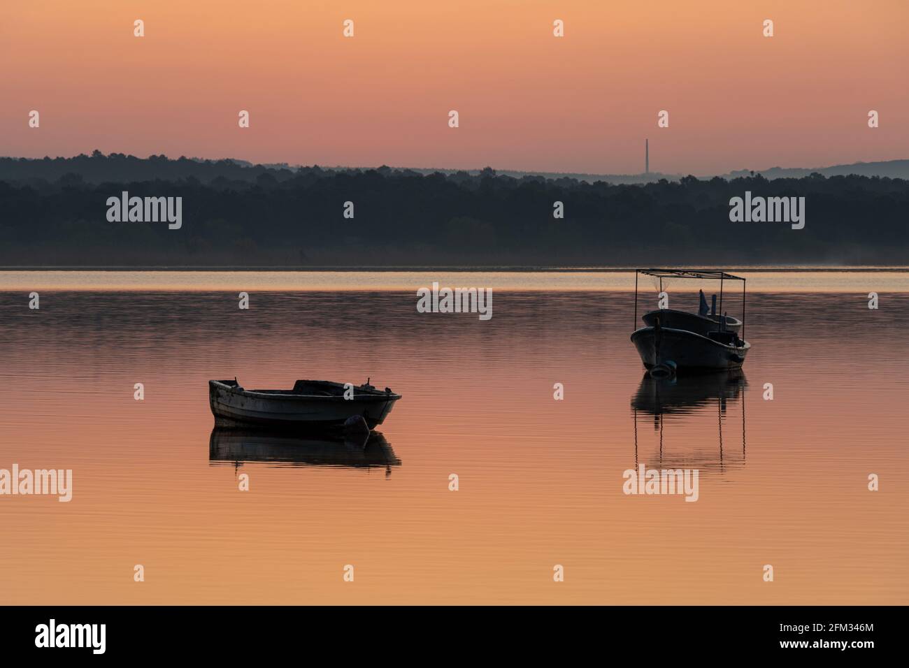 Boote auf dem See bei Sonnenaufgang. Ruhige Landschaft mit Naturkulisse Stockfoto