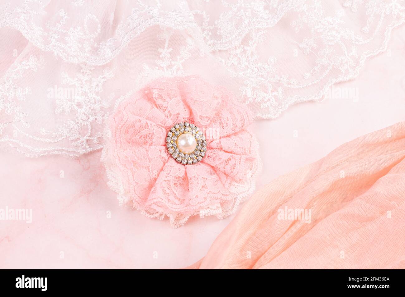 Rosa Spitzenblume mit einer Perle auf einem rosa Hintergrund Stockfoto