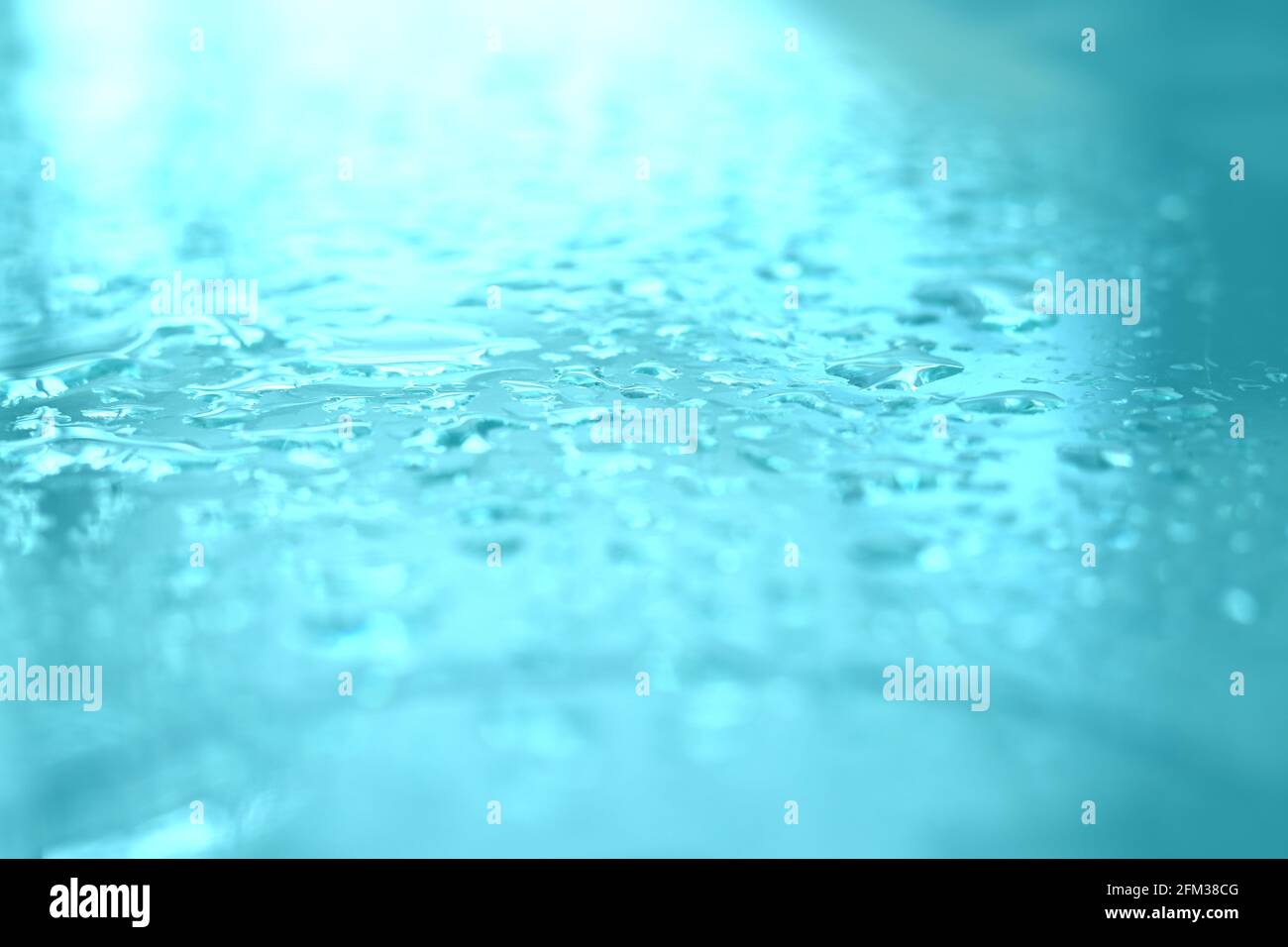 Nahaufnahme von Wassertropfen auf einer türkisfarbenen Oberfläche Stockfoto