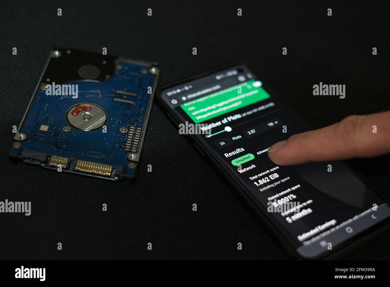 Neue grüne Krypto-Währung Chia auf einem Smartphone, hhd-Speichermünze Bergbauwirtschaft Stockfoto