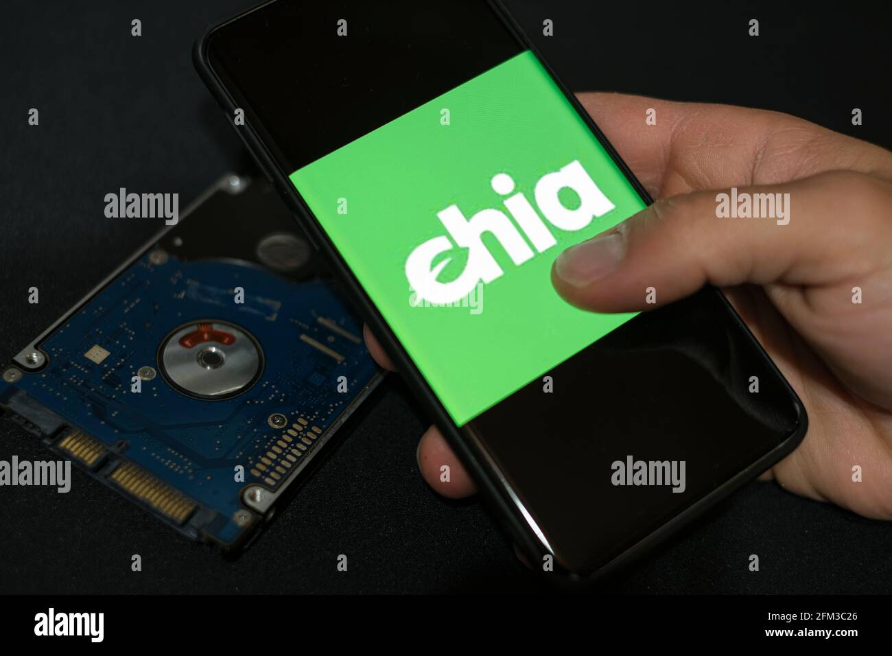 Mann verwenden neue grüne Krypto Währung Chia auf einem Smartphone, hhd Lagerung Münze Bergbau Landwirtschaft Stockfoto