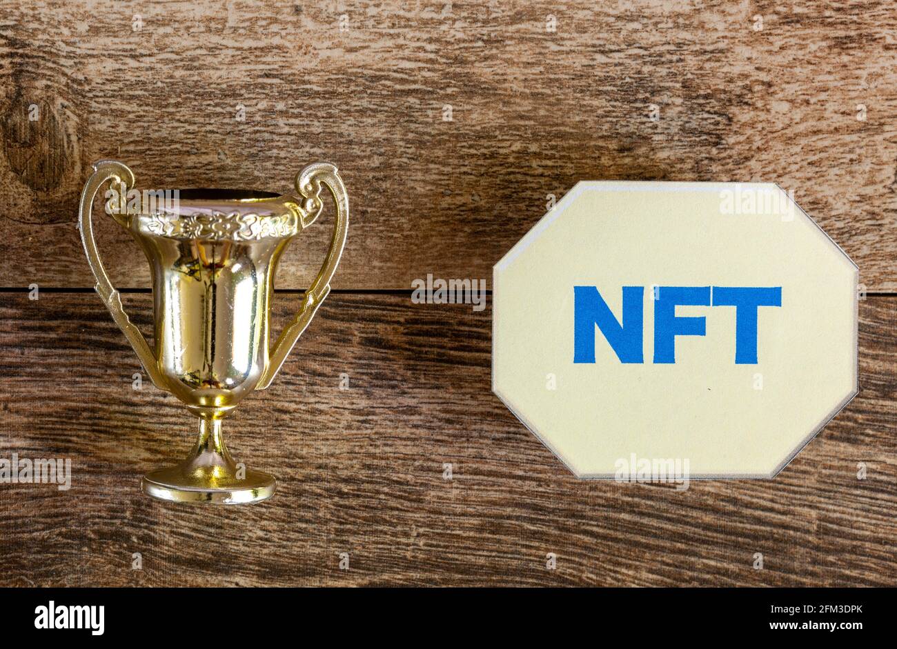 Verwandeln eines Kunstwerks in ein NFT-Konzept (Non fungible Token) mit einer Trophäe auf der einen Seite und einem symbolischen NFT-Token auf der anderen Seite. Auf diese Weise können seltene Gegenstände Stockfoto