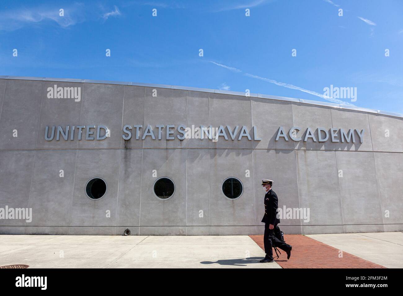 Annapolis, MD, USA 05-02-2021: Ein junger Marineoffizier-Kandidat läuft vor dem Gebäude der United States Naval Academy in Annapolis. Der Kadett Stockfoto