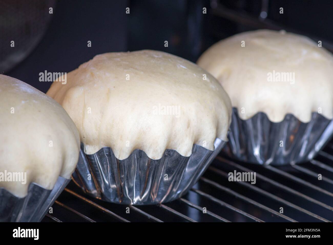 Der Teig für Kuchen in Dosen befindet sich im Ofen Stockfoto