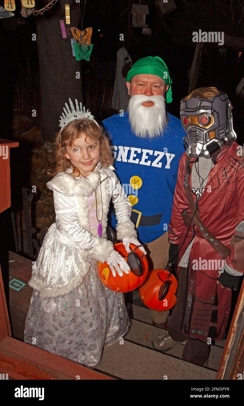 Halloween-Trick und behandelt mit Papa als Sneezy der sieben Zwerge, eine Prinzessin und Star-Lord von Guardians of the Galaxy. St. Paul Minnesota, USA Stockfoto