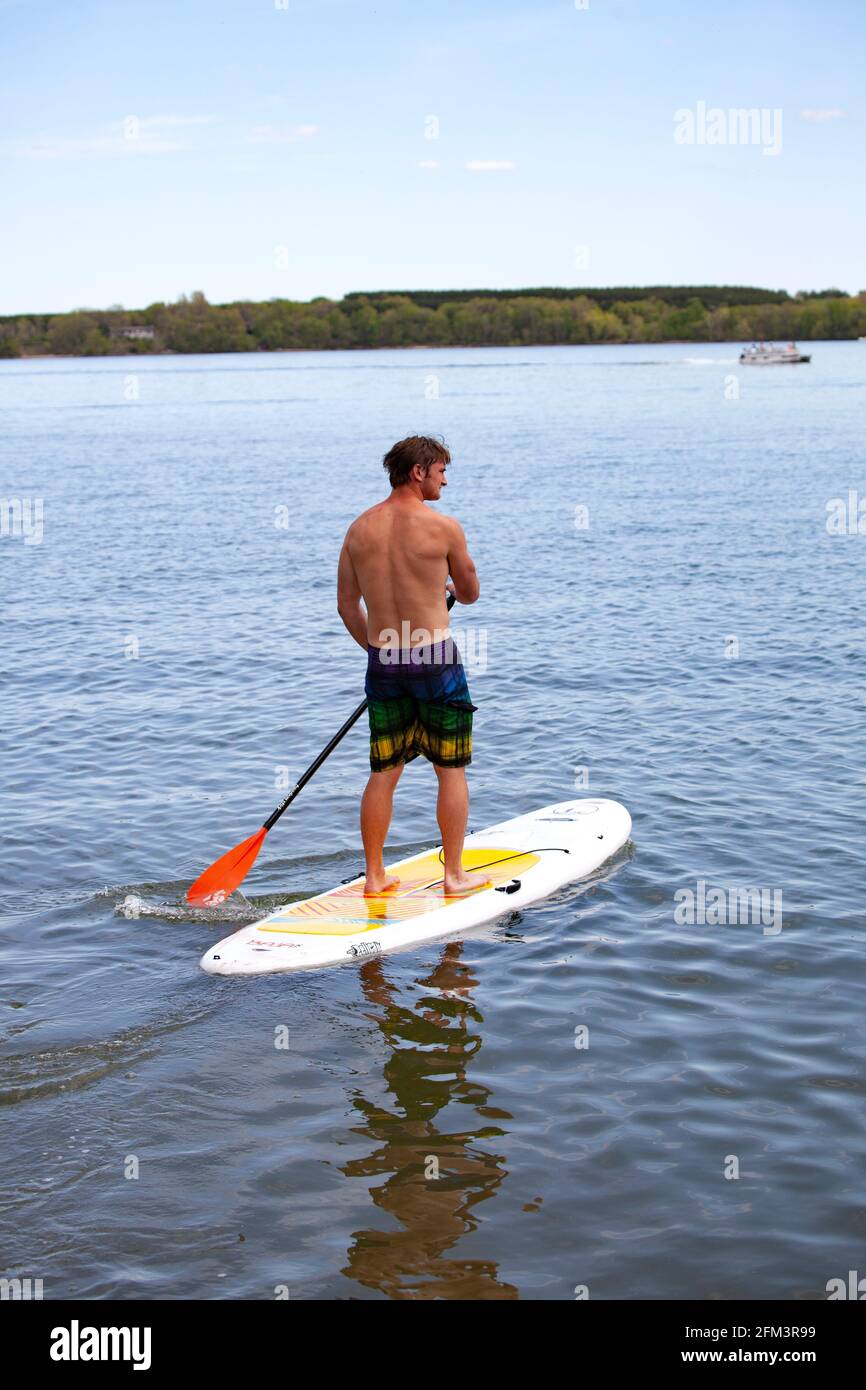 Teen genießt es, sein Paddelbrett auf einem ruhigen Clitherall Lake zu paddeln. Clitherall Minnesota, USA Stockfoto