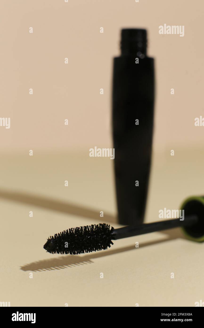 Isolierte Mascara auf neutralem Hinterfransen. Mit Pinsel öffnen, schwarz. Fokus auf Pinsel Stockfoto
