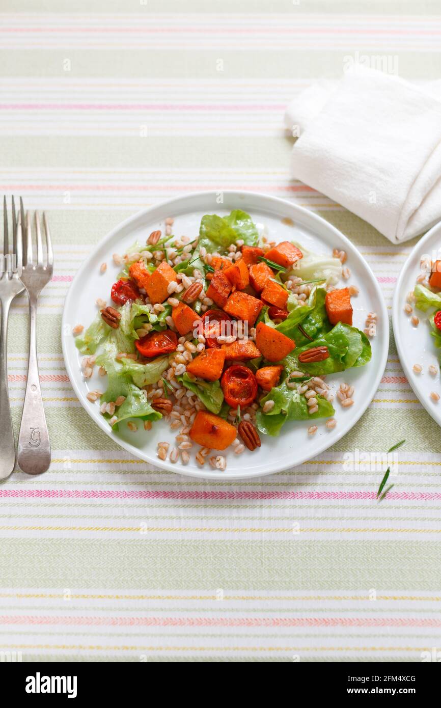 Süßkartoffelsalat mit gerösteten Tomaten mit Dinkelsalat und Rosmarin Pekannüsse Stockfoto