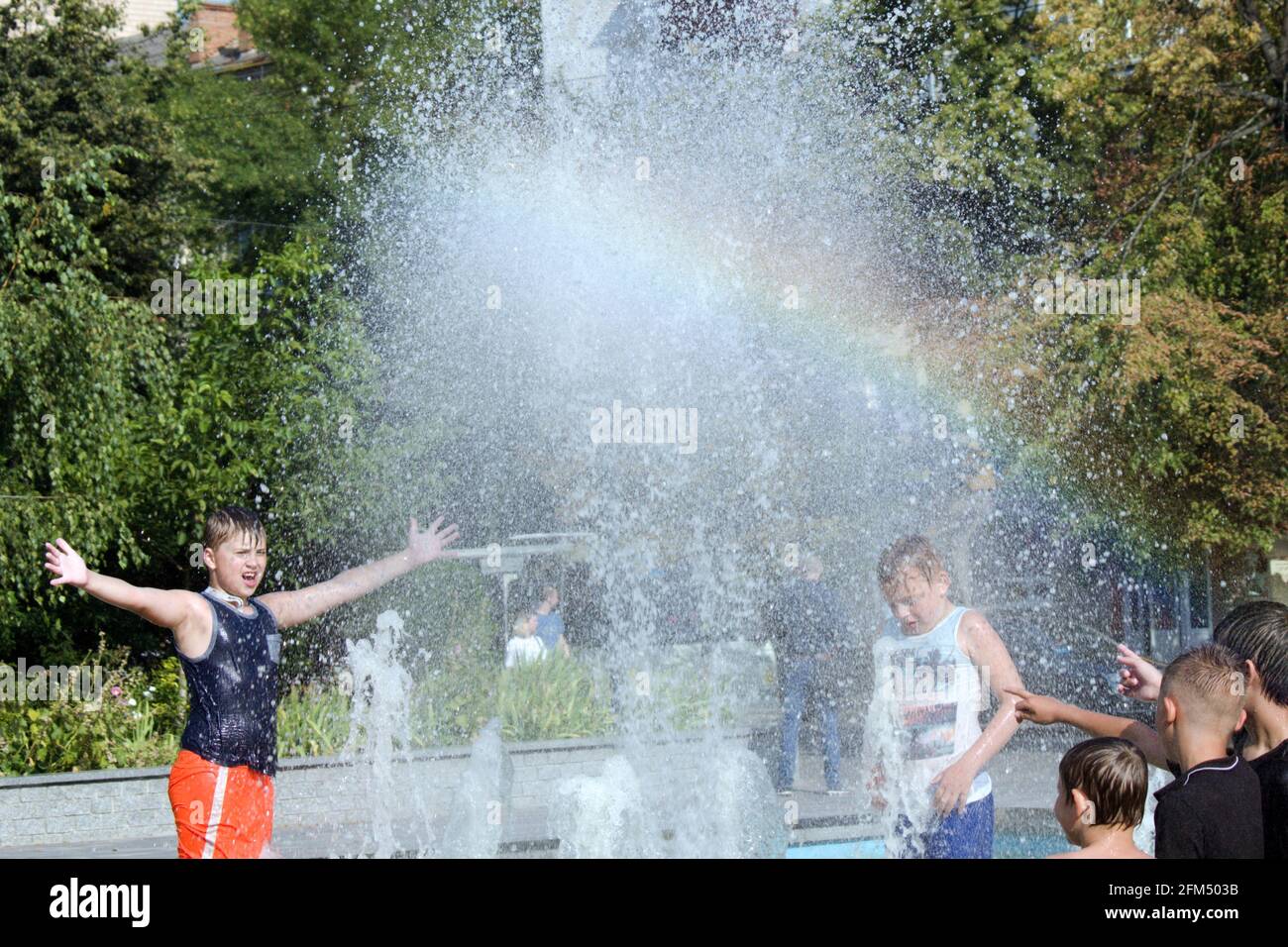 Nasse Kinder, die im Brunnen spielen Stockfoto