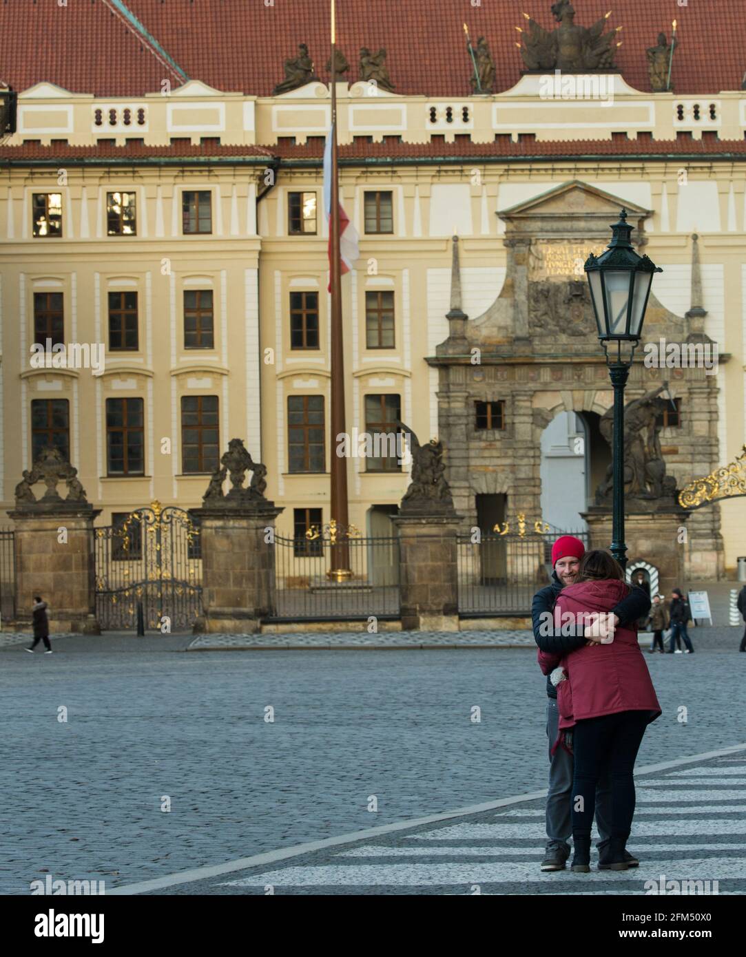 Ein glückliches Paar umarmt sich vor dem Eingang zur Prager Burg auf dem Hradcanske Platz, Prag, Tschechische republik Stockfoto