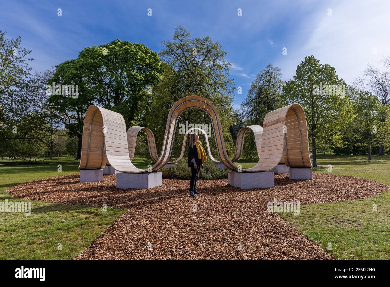 Kew Gardens, Richmond, Großbritannien. Mai 2021. Sommer bei Kew: Die geheime Welt der Pflanzen. Model genießt die immersive Skulptur 'Please be seated' von Paul Cocksedge. Das immersive Sommerfestival umfasst die wunderbare Welt der Pflanzenbiodiversität durch neu in Auftrag gegebene interaktive Kunstinstallationen mit Musik, Klang und Farbe. Im Zentrum des Festivals stehen sechs riesige ‘„Plantscapes“, die über die Kew Gardens verteilt sind und die britische Artenvielfalt feiern und vor ihrem Niedergang warnen. Amanda Rose/Alamy Live News Stockfoto