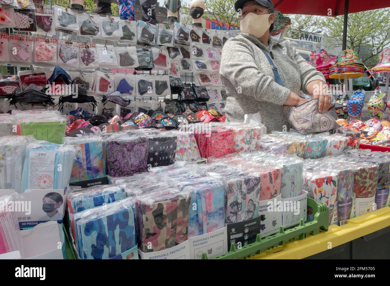 Eine Frau, die am Stand am Junction Boulevard in Corona, Queens, New York, preiswerte Gesichtsmasken verkauft. Stockfoto