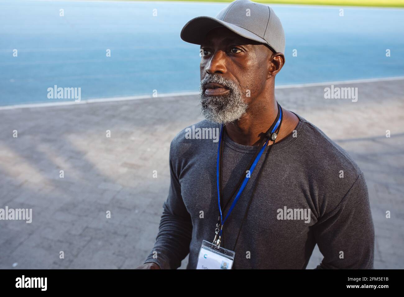 afroamerikanischer Seniortrainer mit Mütze im Stehen Das Stadion Stockfoto