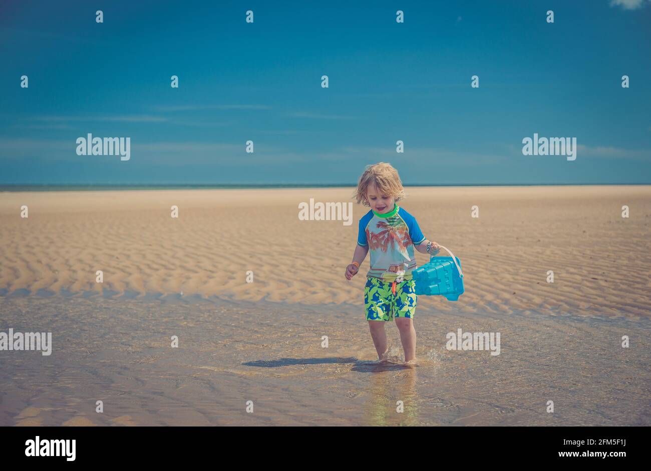 Junger Junge, der am Strand spielt Stockfoto