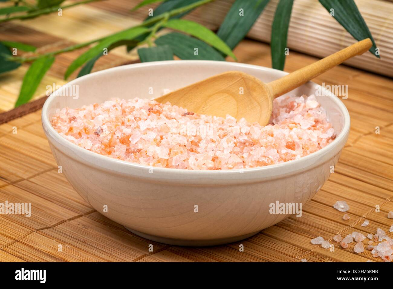 Schüssel mit rotem grobem Himalaya-Salz auf Bambusmatten Stockfoto