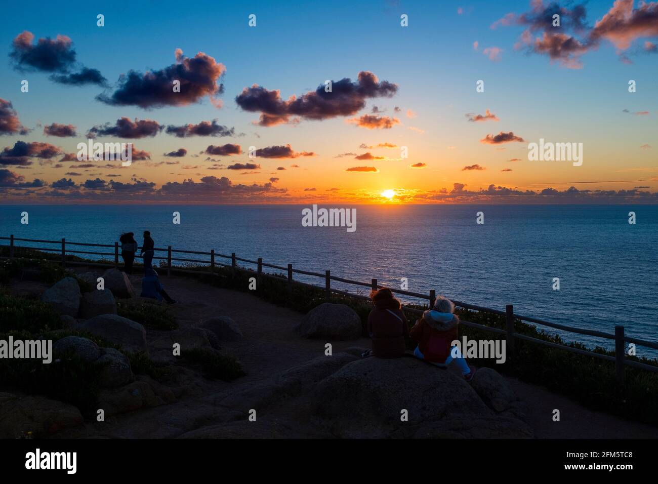 Menschen beobachten den Sonnenuntergang am Cabo da Roca (Kap Roca) in Sintra, Portugal. Stockfoto