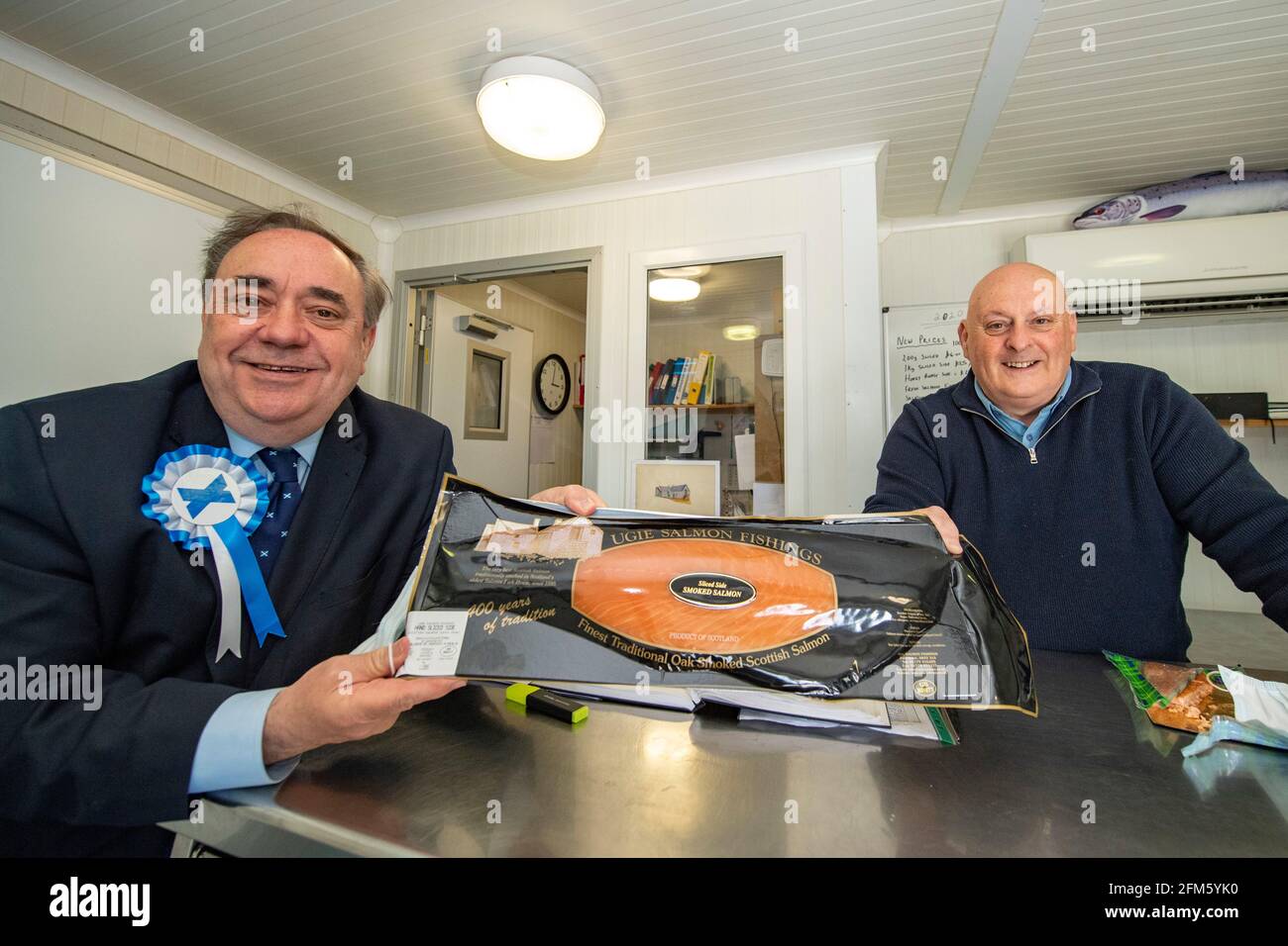 Boddam, Schottland, Großbritannien. Mai 2021. IM BILD: (Links) Alex Salmond, Anführer der Alba-Partei, sah ein Gespräch mit Joseph (rechts), dem Inhaber des lokalen Geschäftsbereichs von Peterhead, Ugie Salmon, dem ältesten Fischhaus Schottlands, das 1585 gegründet wurde. Joseph gibt Alex eine Verkostung und zeigt seine frischen und leckeren Lachsprodukte. Pic Credit: Colin Fisher/Alamy Live News Stockfoto