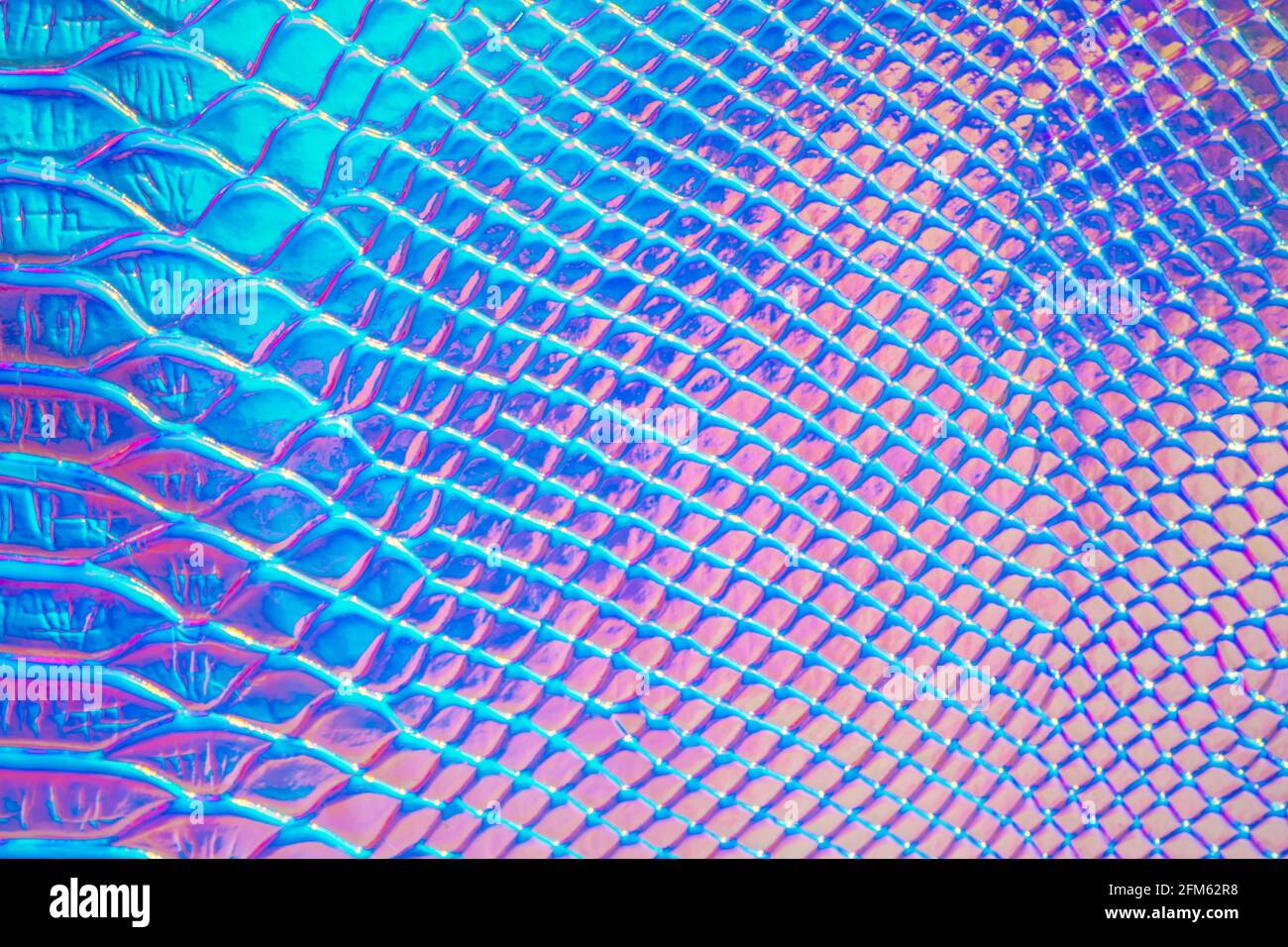 Abstrakter Hintergrund mit holographischen hellen Regenbogen multicolor. Nahaufnahme metallisierter Makros. Nachahmung der Regenbogenfarbe. Hintergrund mit einer Reptilienhaut Stockfoto