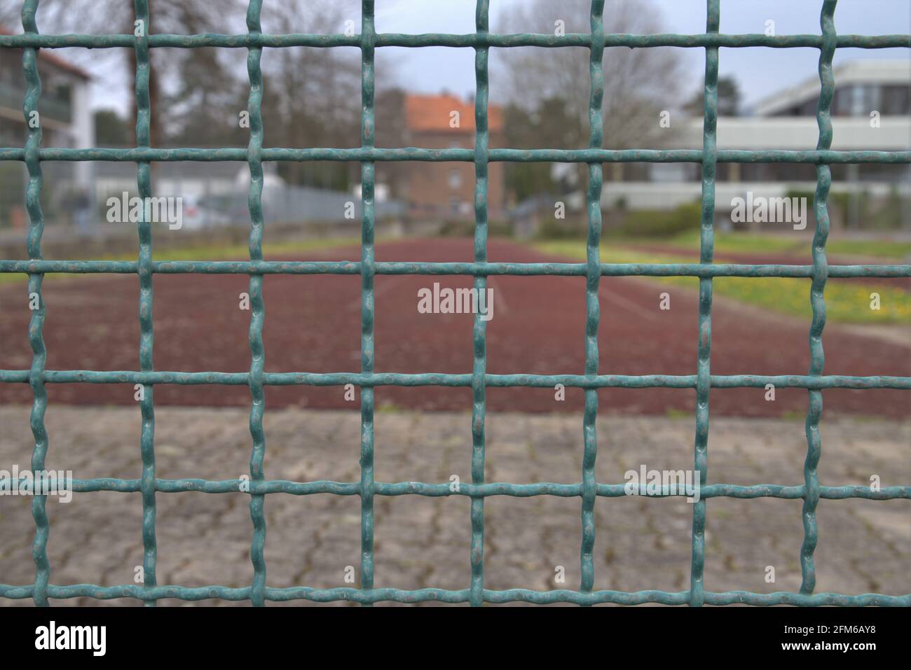 Metallgitterzaun vor einem Spielfeld Stockfoto