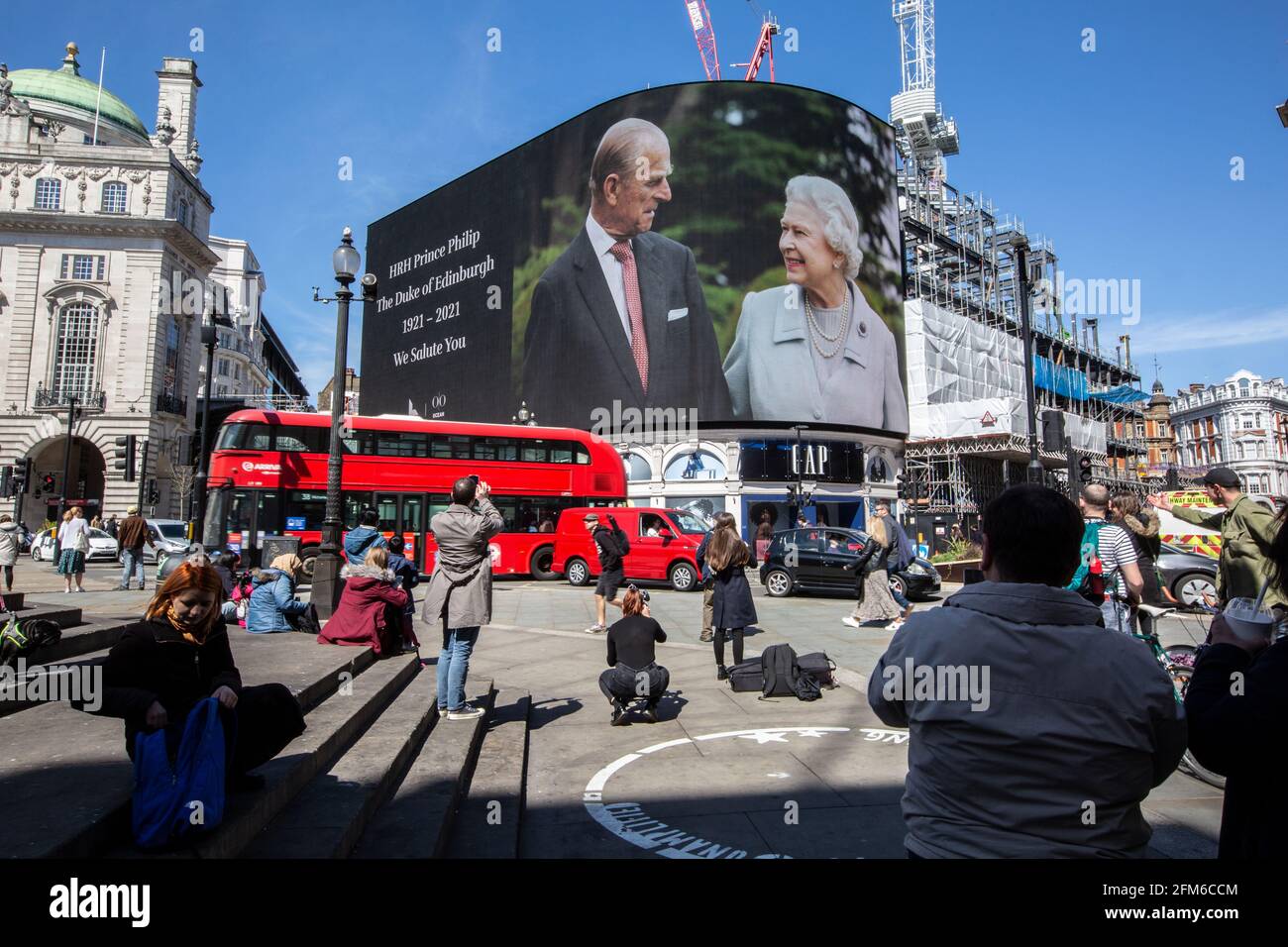Die Leute halten an, um auf den berühmten Werbebildschirm am Piccadilly Circus zu schauen, auf dem eine Hommage an Prinz Philip am Tag seiner Beerdigung in Großbritannien gezeigt wird Stockfoto