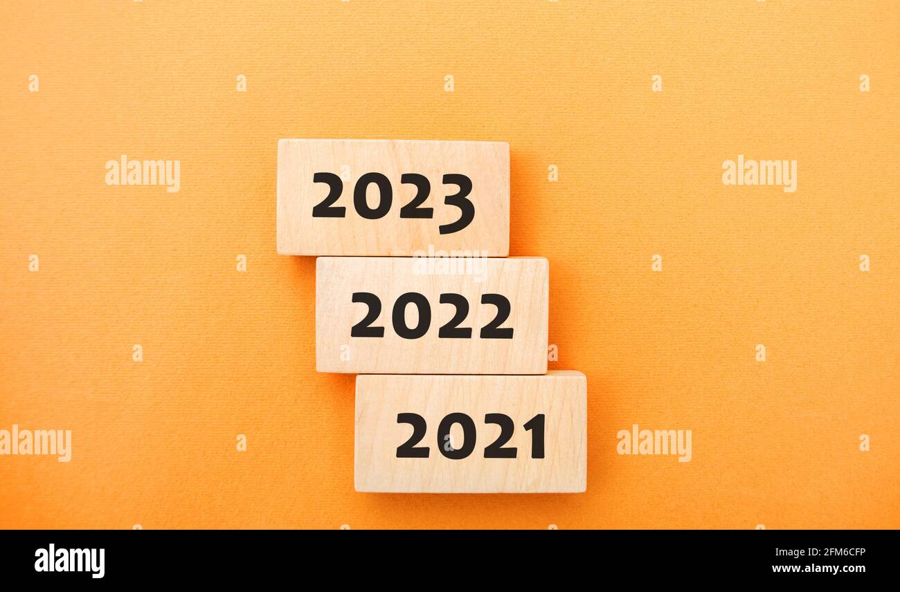 Holzblöcke 2021, 2022, 2023. Das Konzept des Beginns des neuen Jahres. Neue Ziele. Nächstes Jahrzehnt. Trends und Veränderungen in der Welt. Erstellen von Plänen und Stockfoto