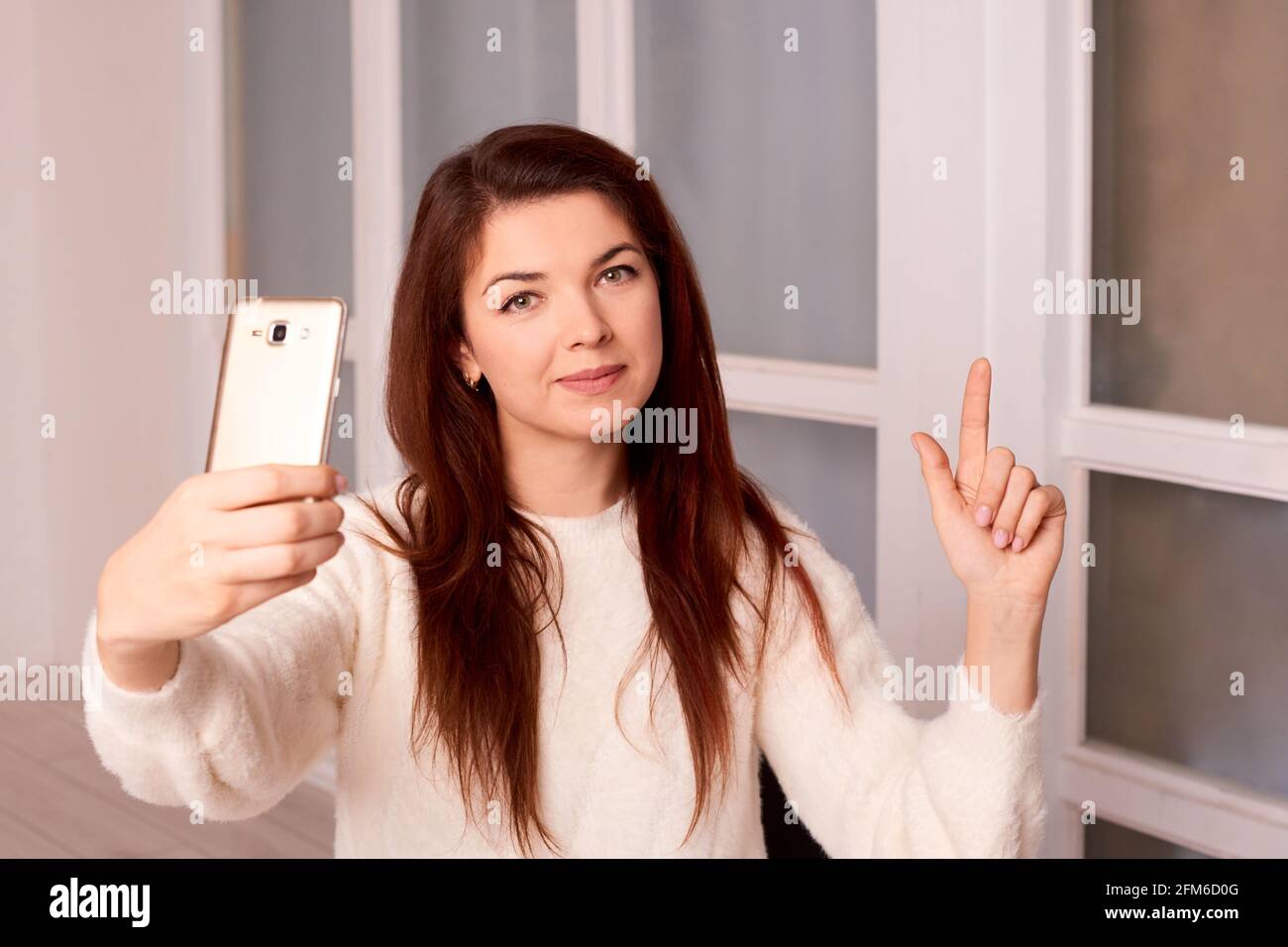 Frau nimmt Videogrüße auf dem Kameratelefon in einer neuen Wohnung auf Oder Haus Stockfoto