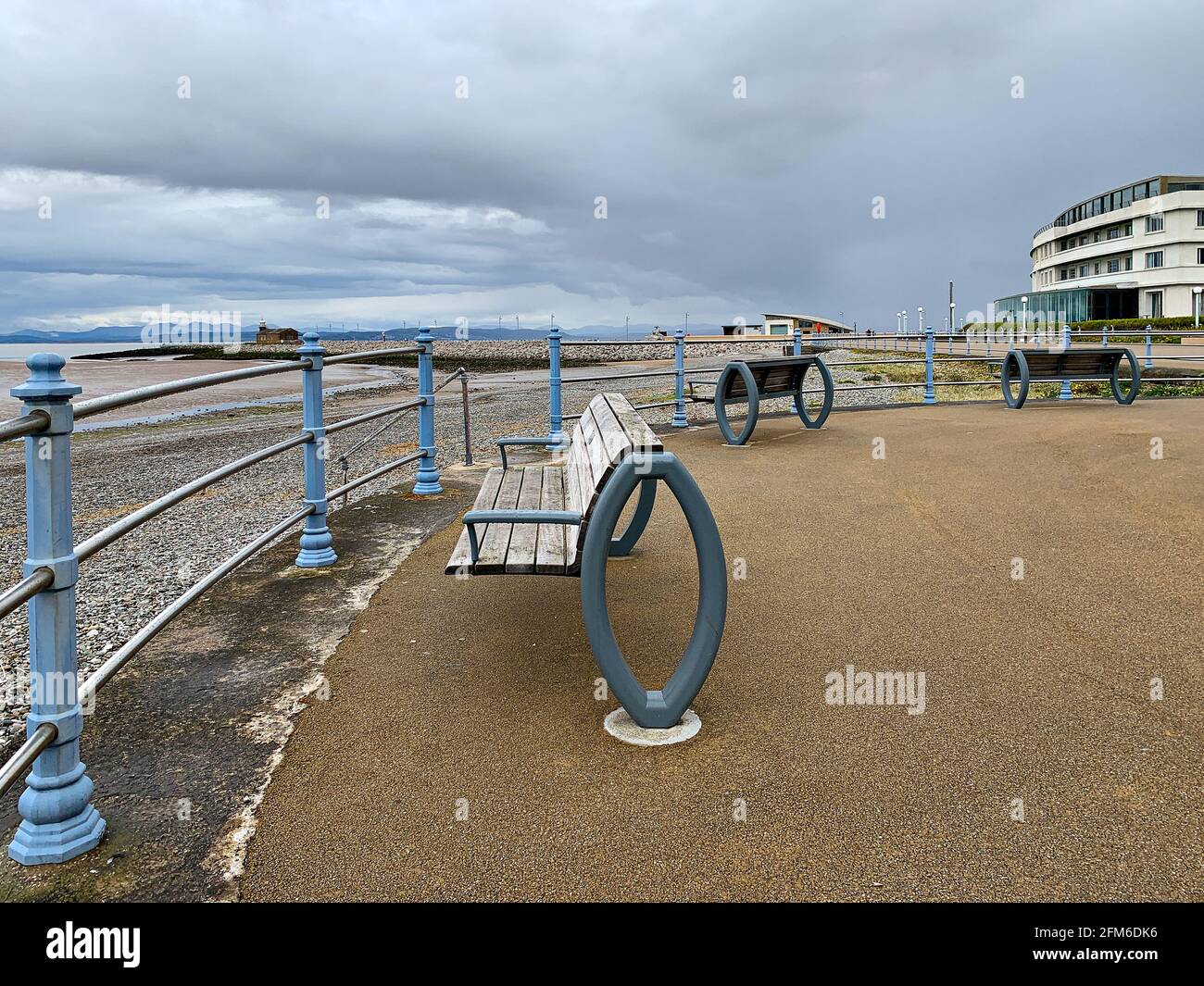 Sitzbank entlang der Promenade von Morecambe mit dem Midland Hotel in Hintergrund Stockfoto