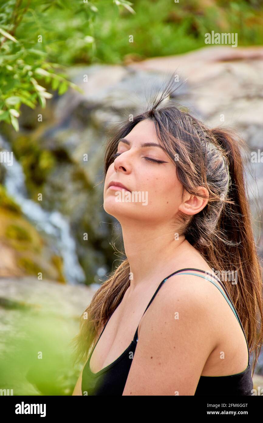 Weiße kaukasische Frau mit braunem Haar im Pferdeschwanz, Augen geschlossen. Konzept, Gefühl, Meditation, Yoga Stockfoto