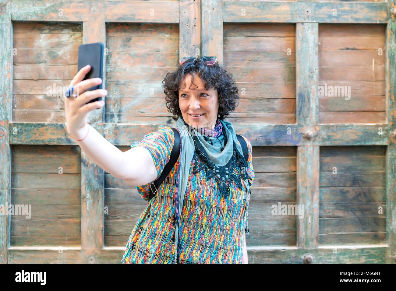 Eine moderne Frau mittleren Alters, die ein Foto von ihrem Smartphone gemacht hat Stockfoto