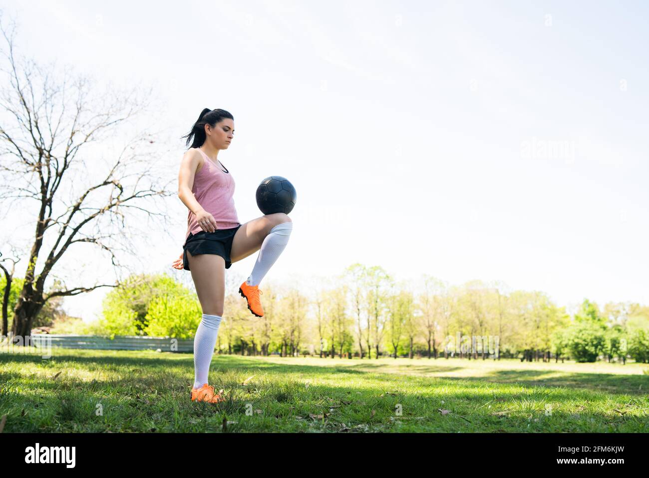 Junge Fußballspielerin übt auf dem Feld. Stockfoto