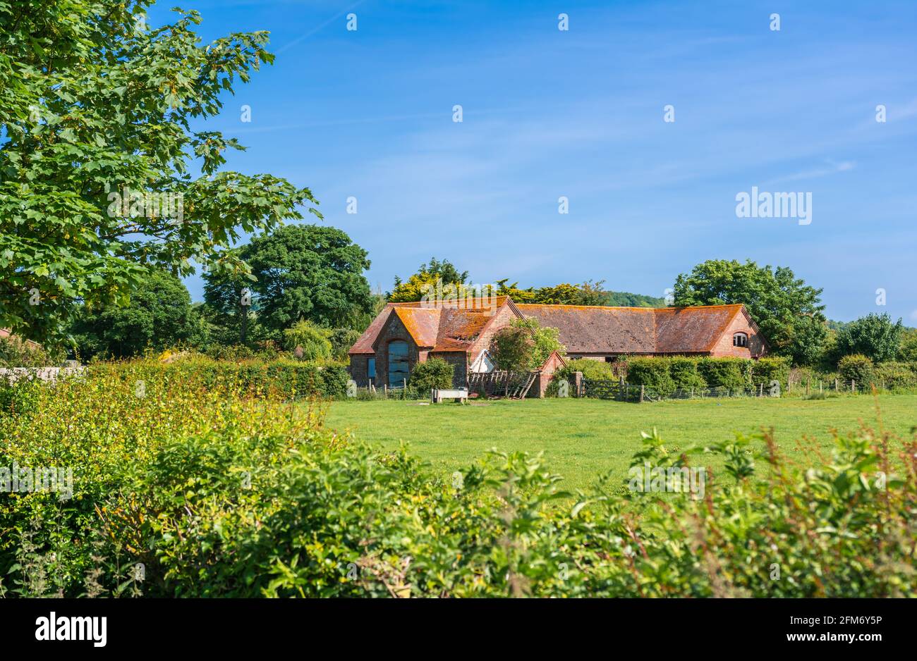 Altes Bauernhaus oder Scheune in einem Feld auf dem Land in England, Großbritannien. Stockfoto