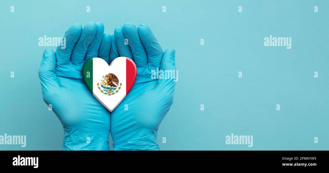Ärzte Hände tragen chirurgische Handschuhe halten Mexiko Flagge Herz Stockfoto