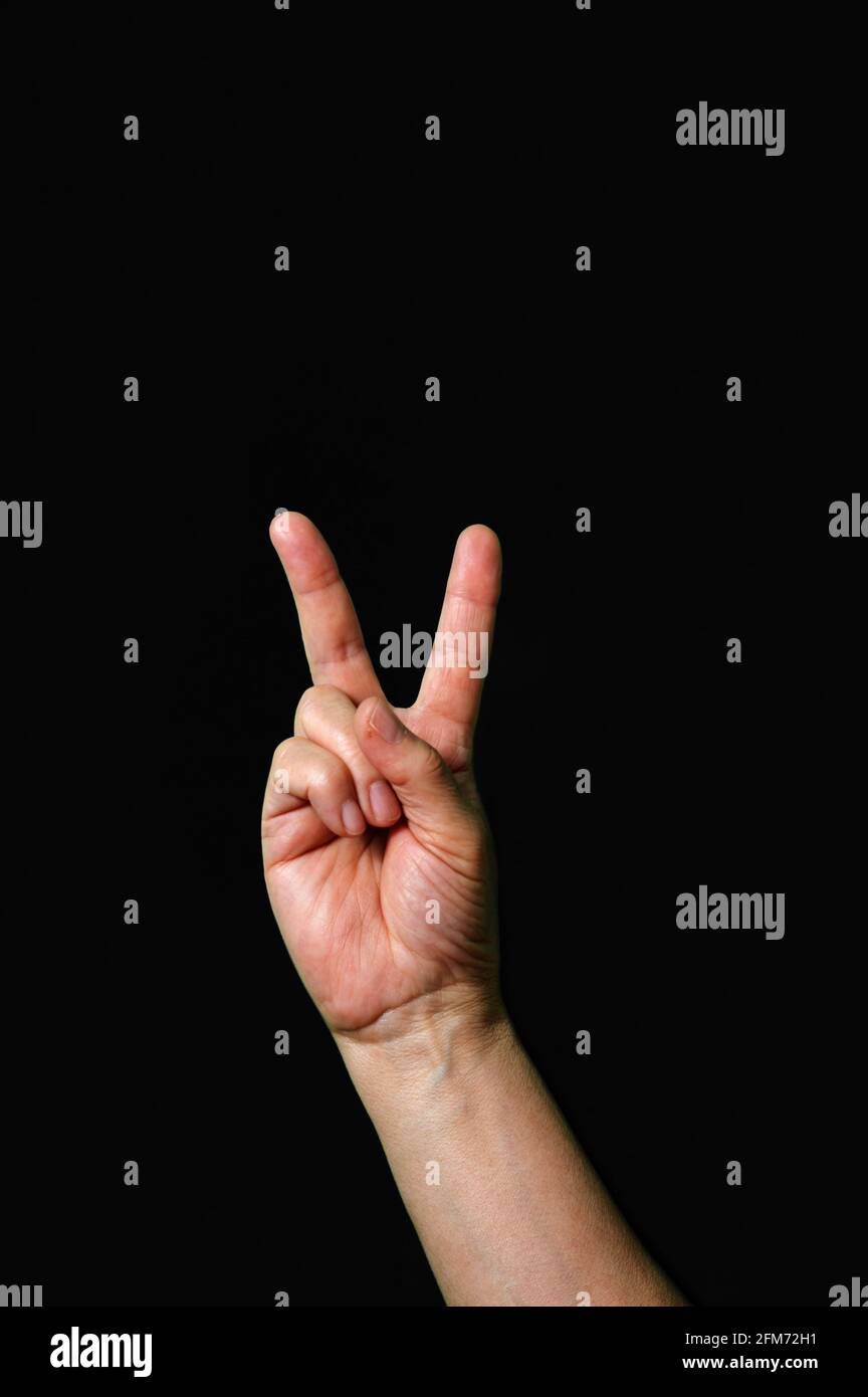 Hand machen und zeigen Brief V Internationale Gebärdensprache dunkel Hintergrund Internationale Zeichensprache dunkler Hintergrund Stockfoto