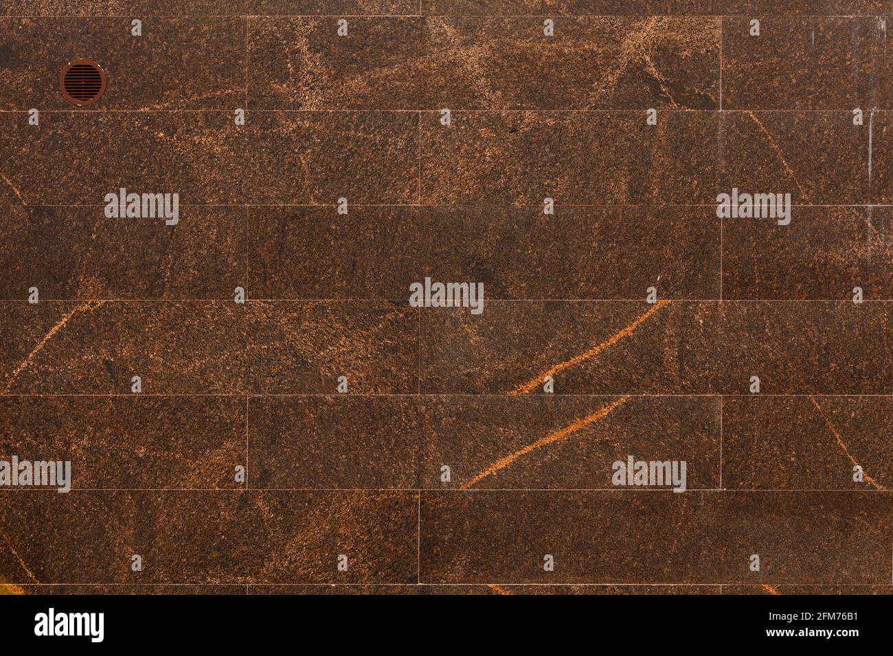Flache Wand mit rechteckigen braunen Granitfliesen Auch bekannt als indischer brauner Granit Stockfoto