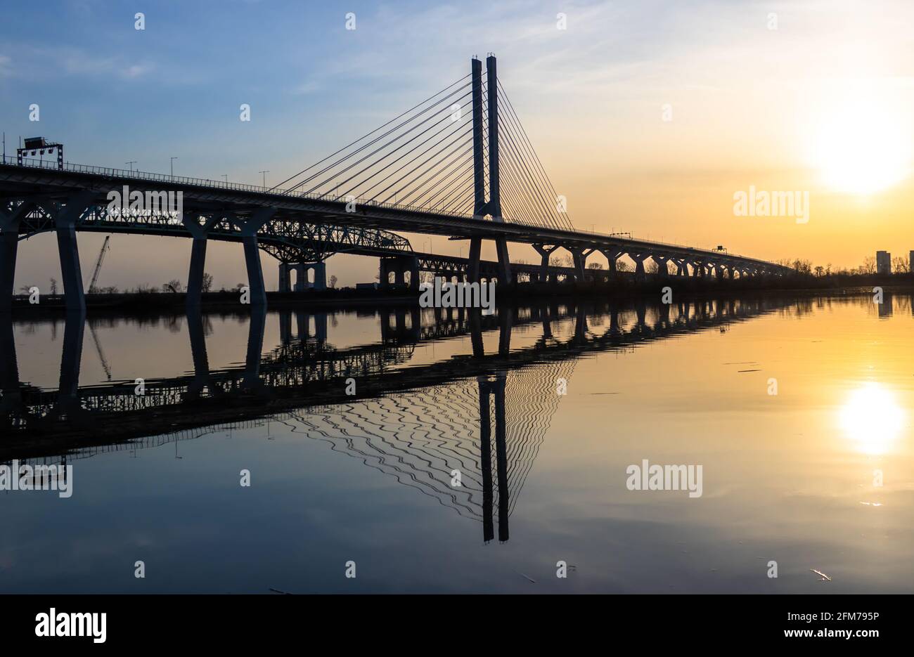 Ein wunderschöner Sonnenuntergang und die Champlain-Brücke in Richtung Montreal von Brossard. Sie spiegelt sich im Sankt-Lorenz-Strom wider. Stockfoto