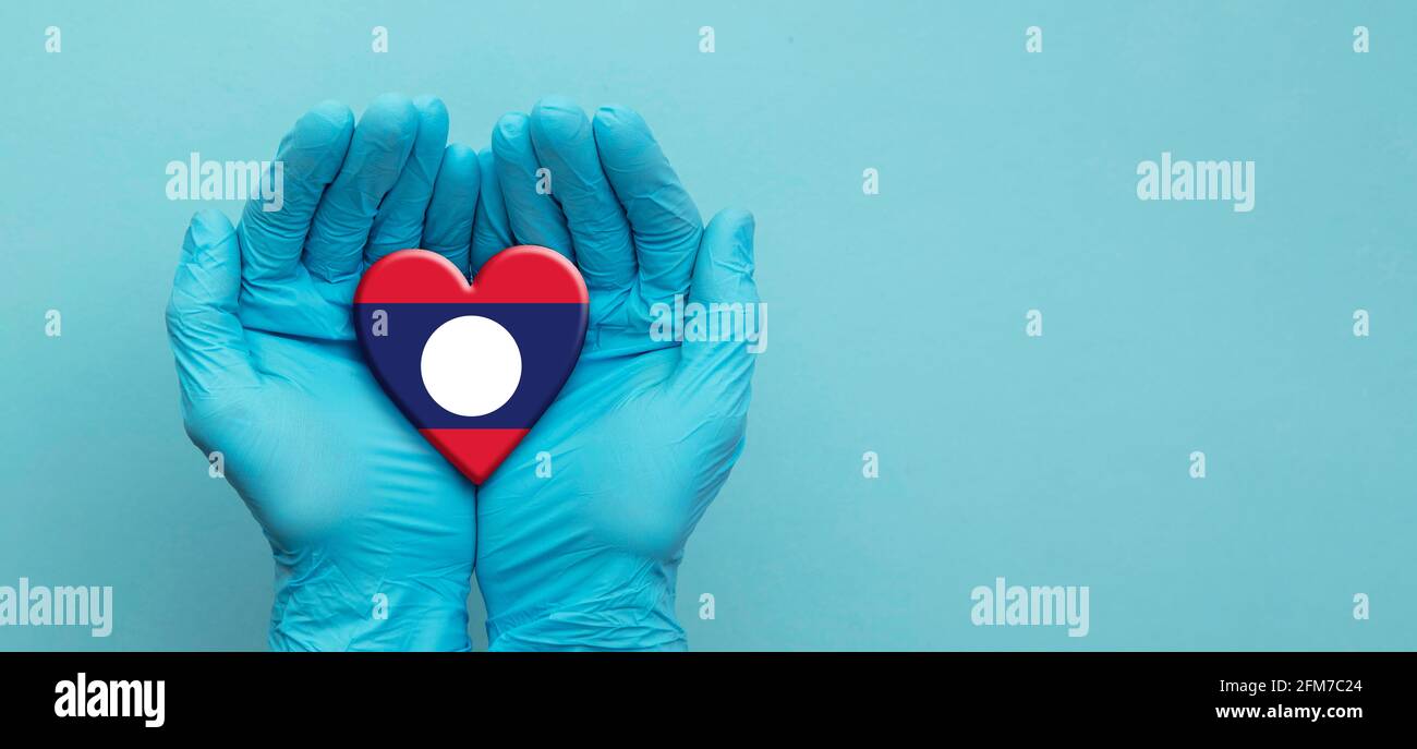 Ärzte Hände tragen chirurgische Handschuhe, die Laos Flag Herz halten Stockfoto