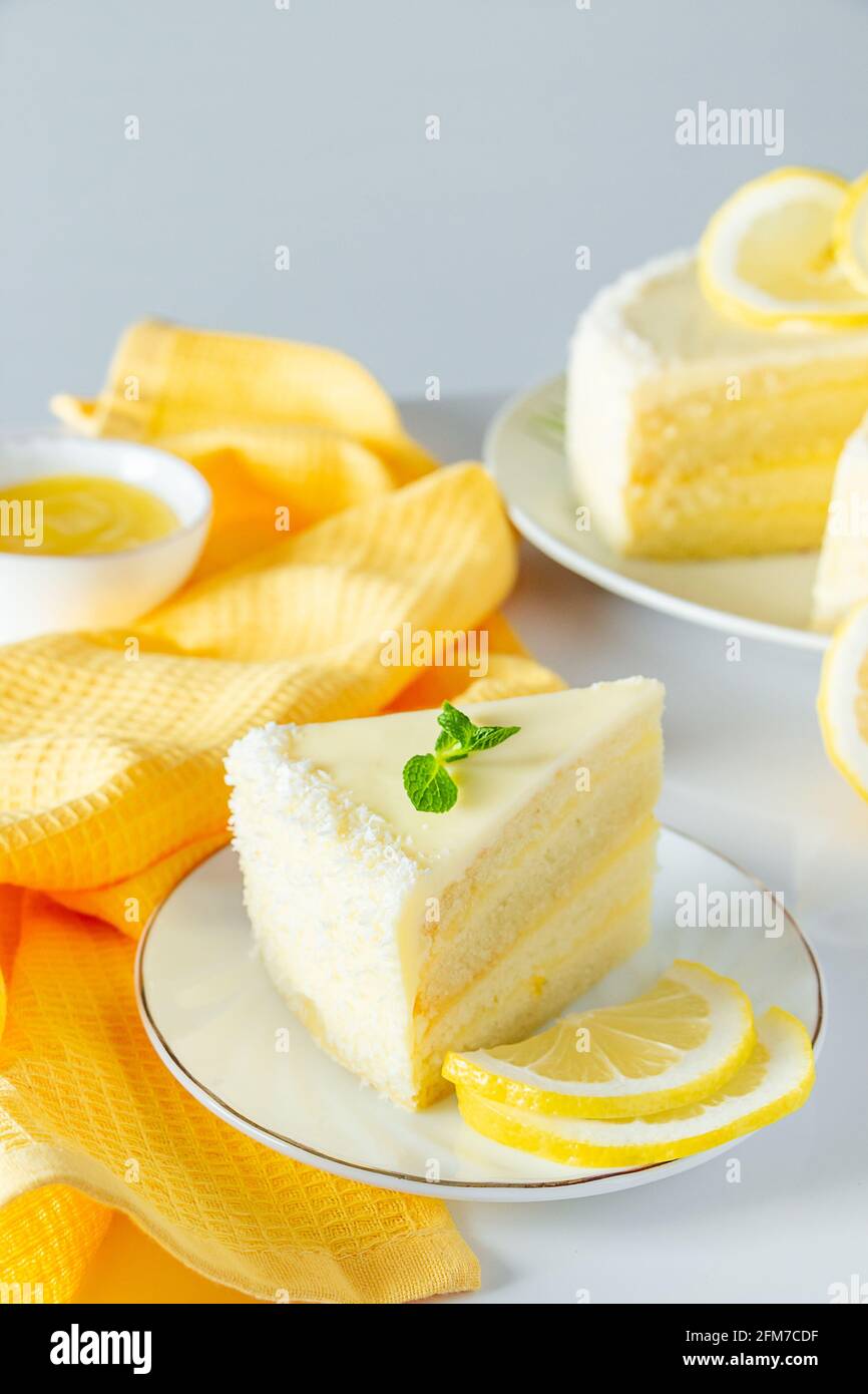 Zitronenkuchen mit Kokosflocken. Ein Stück zartes Vanilledessert mit Rahm. Stockfoto