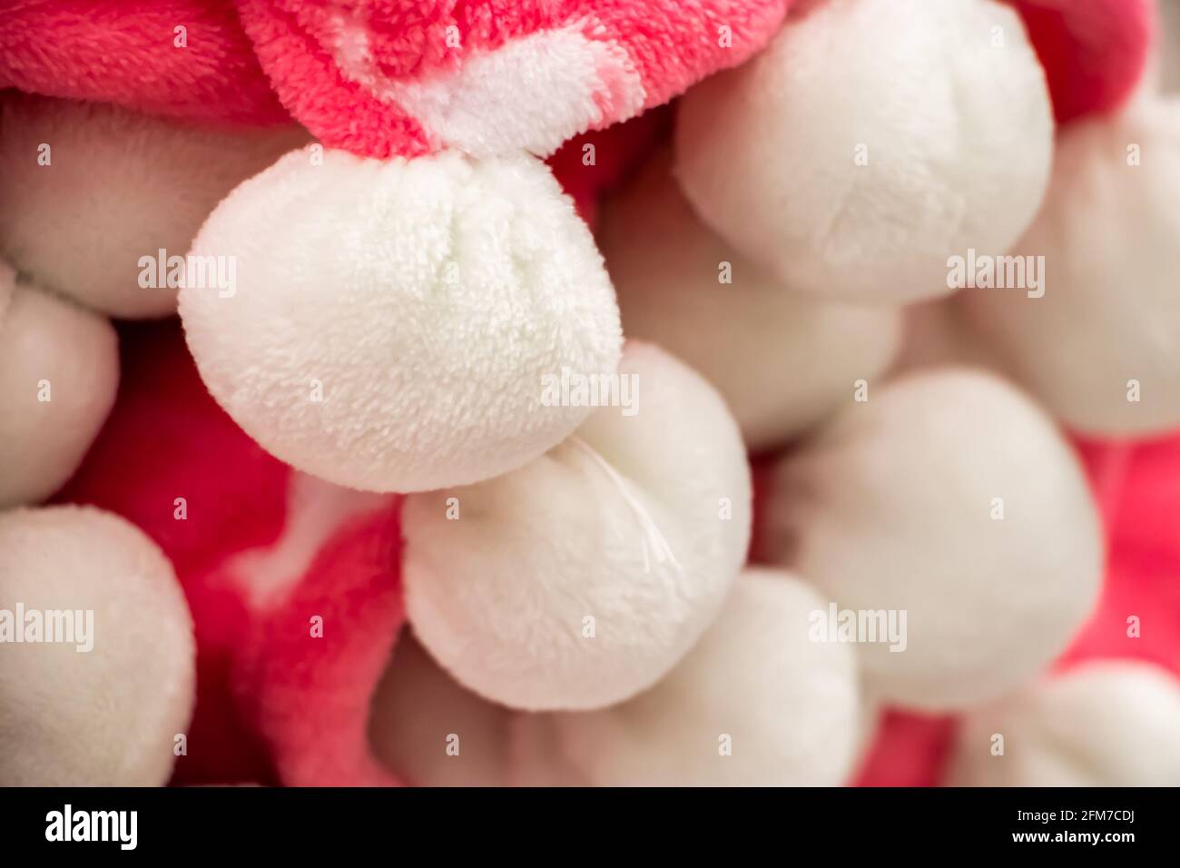 Rosa karierten mit weißen Pompons. Ein warmes Accessoire für einen gemütlichen Herbst. Stockfoto