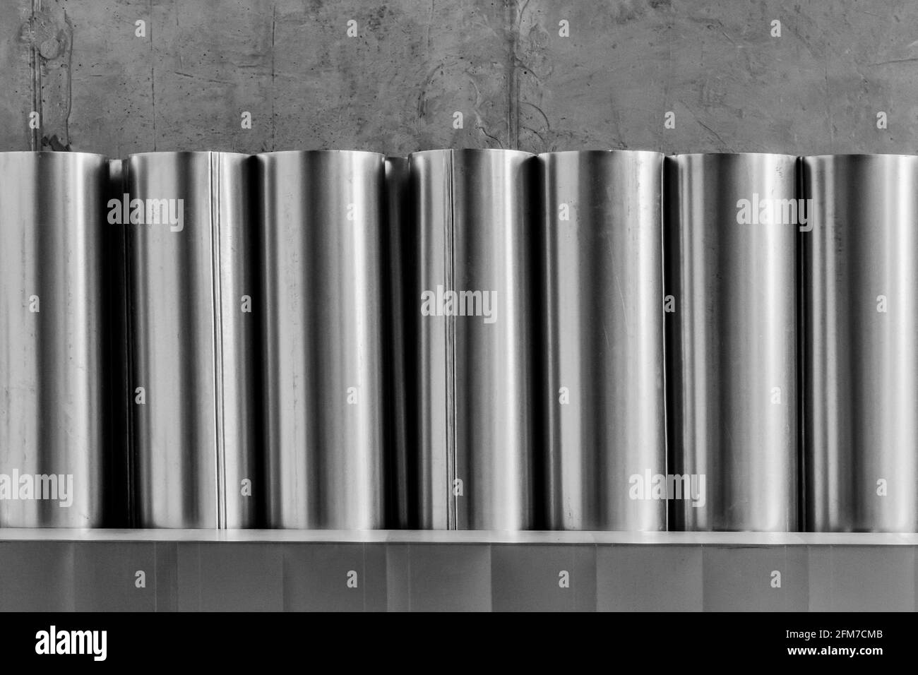 Stapel von runden Metallrohren auf einer Baustelle. Lagerung von Industriematerialien für Stahlrohre im Lager Stockfoto