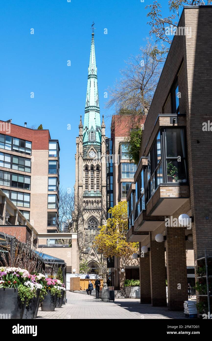 Die anglikanische Saint James Cathedral ist in andere Gebäude der Altstadt von Toronto, Kanada, eingefasst. Das Bild zeigt die Glocke und den Uhrenturm Stockfoto