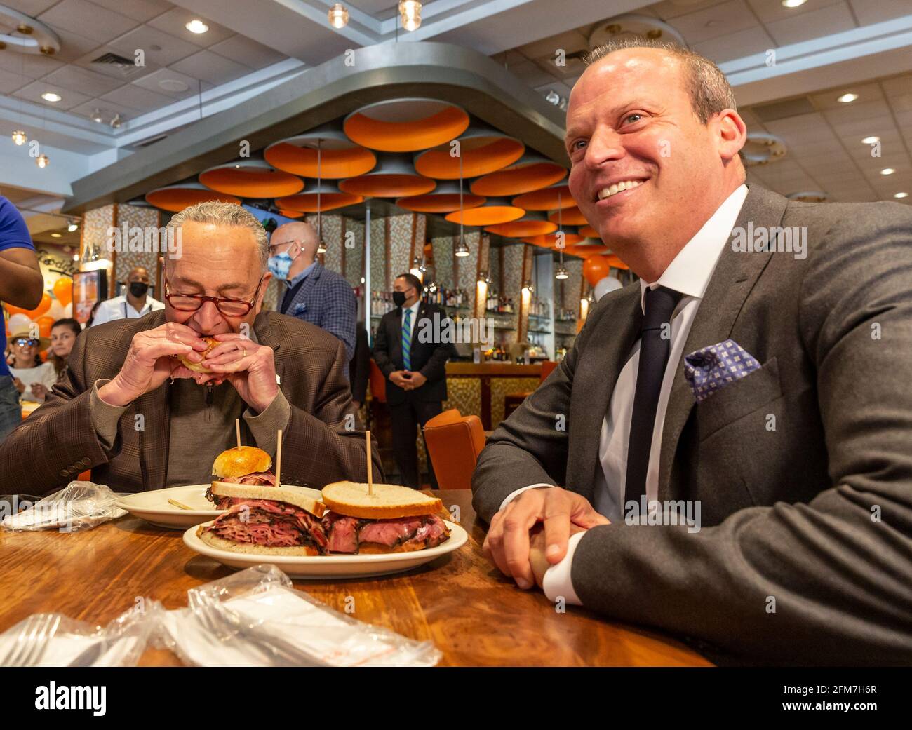 U. S. Senator und der Mehrheitsführer des Senats, Charles Schumer, markieren die Wiedereröffnung des Junior's Cheesecake Restaurants am Times Square. Er war maßgeblich an der Verabschiedung der Hilfsmaßnahmen beteiligt, um kleine Unternehmen wie Restaurants nach der Verwüstung durch die COVID-19-Pandemie offen zu halten. Senator aß ein Stück leckeren Käsekuchen und frühstückte. Senator wurde als Kind in dieses Restaurant eingeführt und unterstützt es seitdem weiterhin. Auf der linken Seite des Senators befindet sich der Besitzer des Restaurants Alan Rosen. (Foto von Lev Radin/Pacific Press) Stockfoto