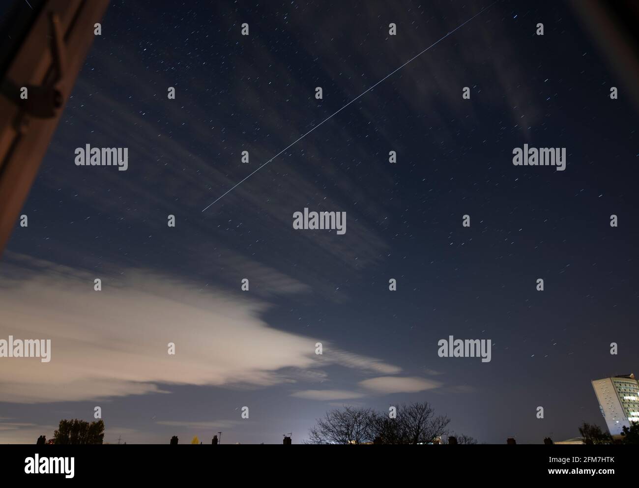 Wimbledon, London, Großbritannien. 7 Mai 2021. Im Südwesten Londons wird die Meteoritenschauerjagd von Aquarids ausgerufen, da sich in den frühen Morgenstunden eine zunehmende Wolke aufbaut. Die Internationale Raumstation macht um 02.35 Uhr einen hellen Pass über London. Dieses zusammengesetzte Bild des ISS-Trails besteht aus mehreren 8-Sekunden-Bildern und wurde durch ein offenes Fenster aufgenommen. Quelle: Malcolm Park/Alamy Live News. Stockfoto