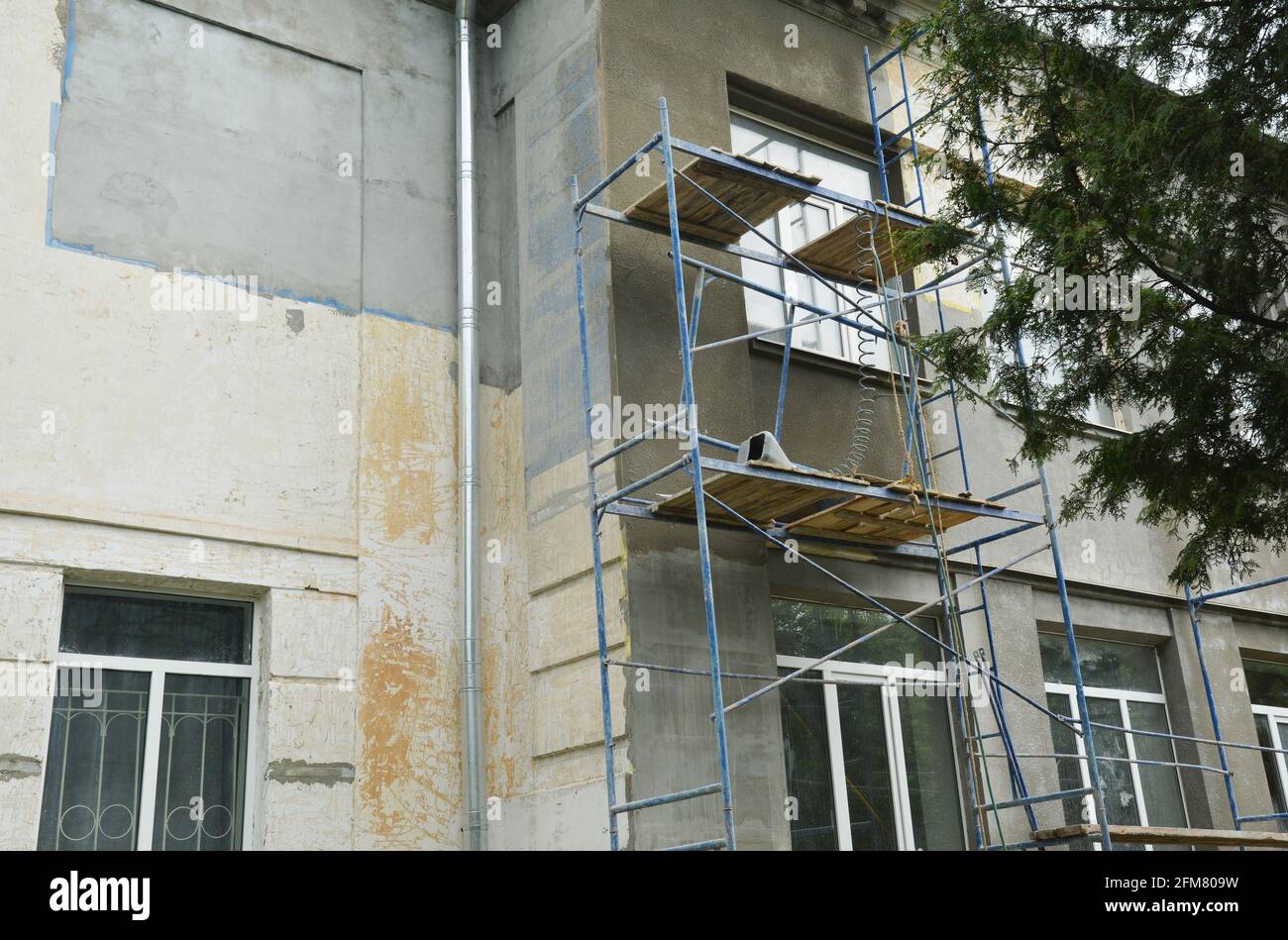 Gebäudereparatur und Fassadensanierung durch Verputzen der Fassadenwände und Stuckarbeiten. Verputzen der Fassade vor dem Lackieren. Stockfoto