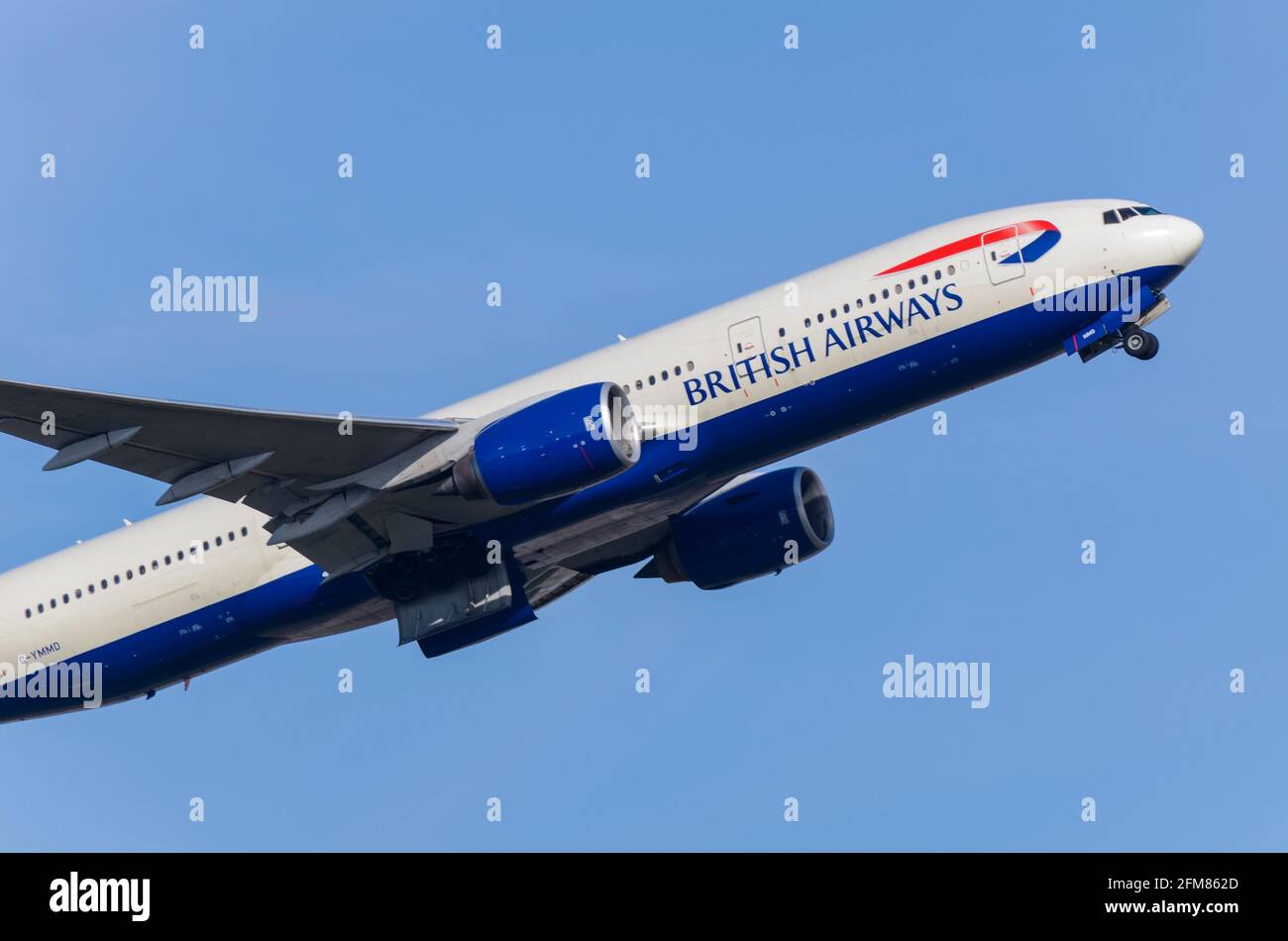 British Airways Boeing 777 Jet-Linienflugzeug G-YMMD steigt nach dem Start vom Flughafen London Heathrow, Großbritannien, in blauem Himmel aus. Abheben Stockfoto