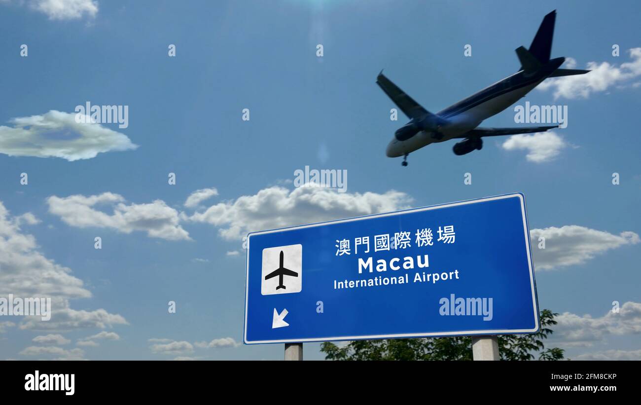 Flugzeug Silhouette Landung in Macau, China. Ankunft in der Stadt mit Schild Richtung Flughafen und blauem Himmel im Hintergrund. Reisen, Reisen und Stockfoto