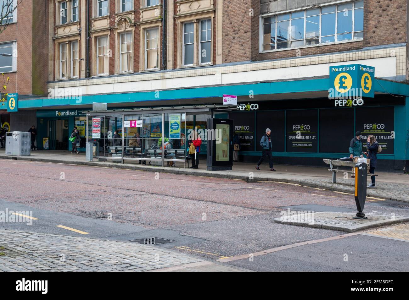 Norwich Poundland Shop auf der St. Stephen’s Street Norwich mit Bushaltestelle auf dem Bürgersteig. Stockfoto