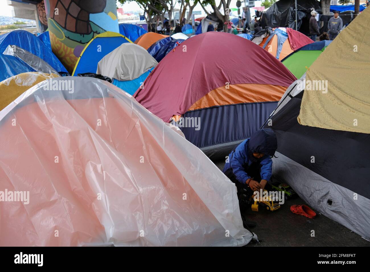 Ein Migrantenkind spielt mit Spielzeugautos in einem provisorischen Lager am Grenzhafen von El Chaparral, der in die USA einführt, in Tijuana, Mexiko, am 23. April 2021. Bild aufgenommen am 23. April 2021. REUTERS/Toya Sarno Jordan Stockfoto