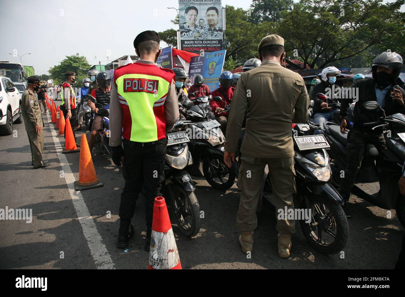 West Karawang, Indonesien. 7 2021. Mai: Die Beamten führen während der Zeit des Verbots, in ihre Heimatorte zurückzukehren, um Eid al-Fitr zu feiern, Blockaden bei der Tanjungpura Blockage Check Point Post, West Karawang durch. An der Grenze zwischen Bekasi und Karawang wurde die Überwachung der vorbeifahrenden Fahrzeuge der Anwohner verschärft. Dutzende von Bewohnern, die sowohl Motorräder als auch Autos benutzten, wurden von den Beamten gebeten, eine Kehrtwende zu machen. Quelle: Pacific Press Media Production Corp./Alamy Live News Stockfoto