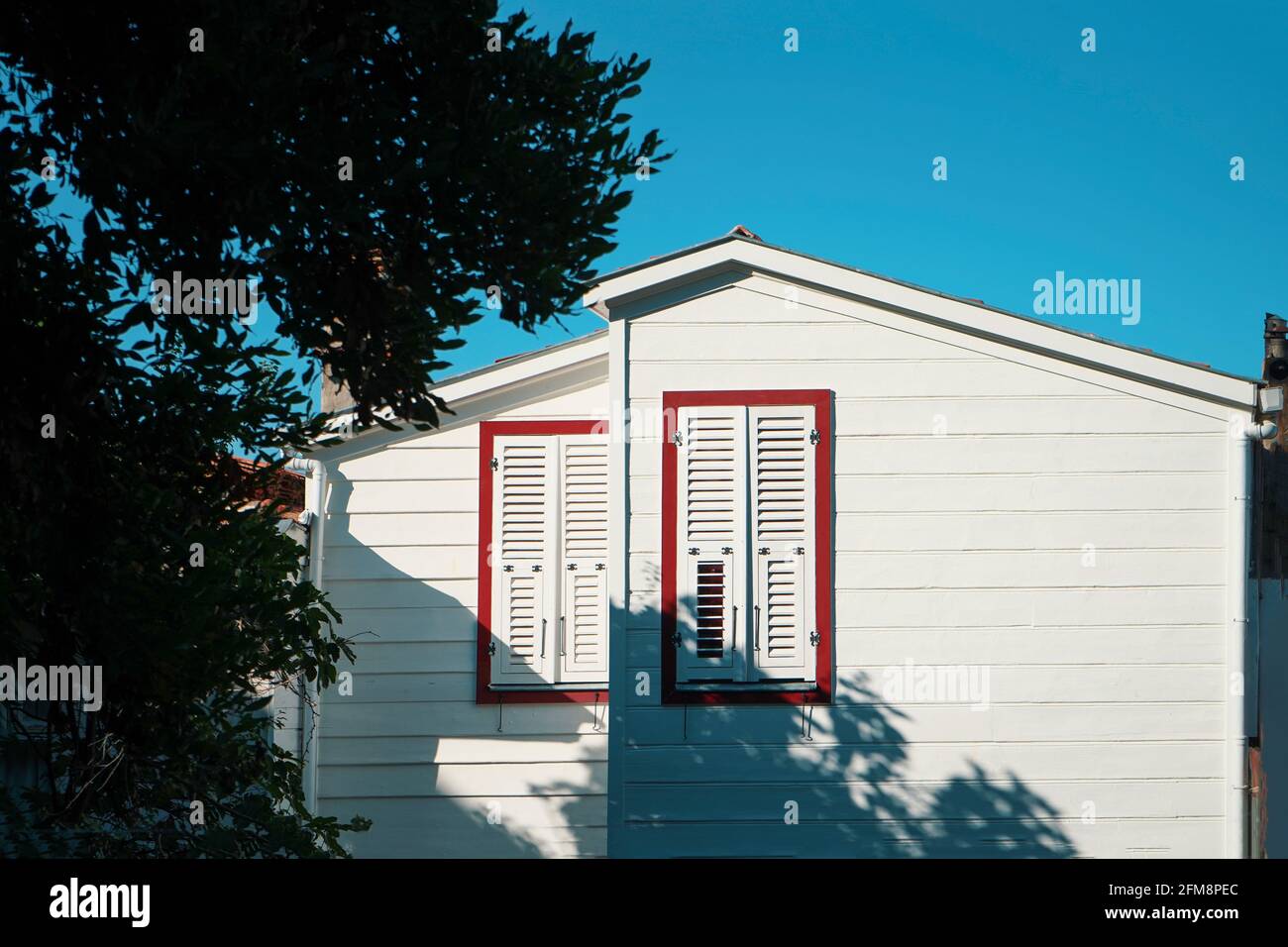 Außen und zwei Fenster eines schönen alten Holzhauses Mit einer Perspektive Stockfoto